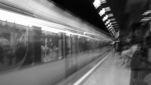 Black and white motion blur of a subway train in an underground station, capturing urban energy.